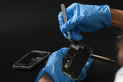 Technician repairing the smartphone's motherboard in the lab with copy space.