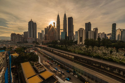 Aerial view of buildings in city against cloudy sky