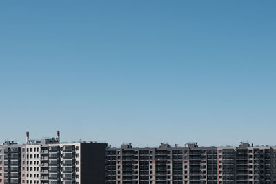 Exterior of modern buildings against clear blue sky