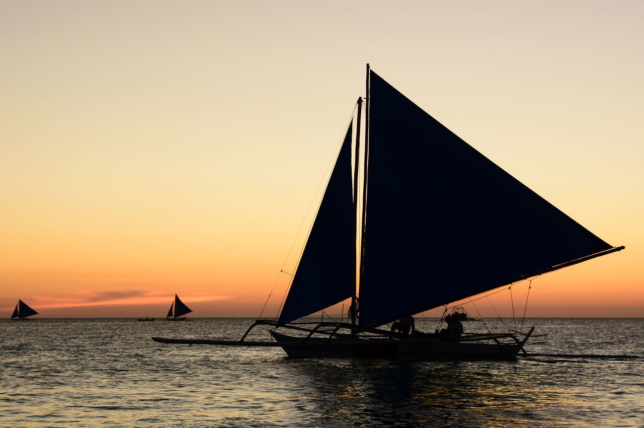 SILHOUETTE SAILBOAT ON SEA AGAINST ORANGE SKY