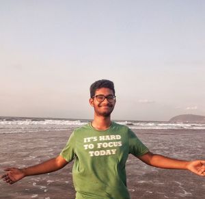 Young man looking at sea against sky