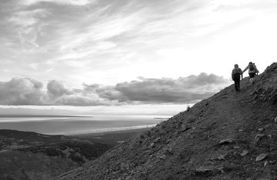 Panoramic shot of people standing on land against sky