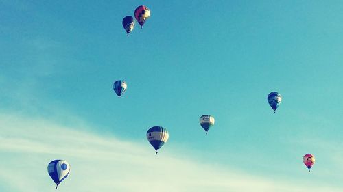 Low angle view of hot air balloons against blue sky