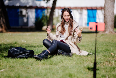 Portrait of young woman sitting on grassy field