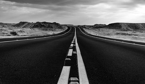 Road leading towards mountain against sky