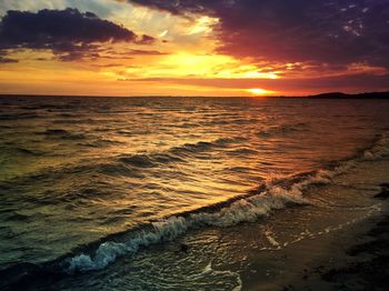 Scenic view of sea against dramatic sky during sunset