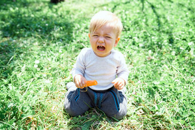 Boy sitting on field