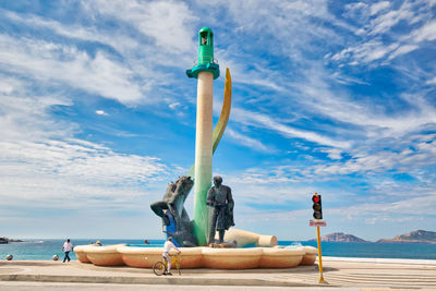 Sculpture on beach against sky