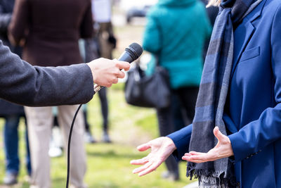 Journalist making media interview with elegant unrecognizable female person