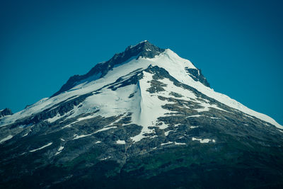 Scenic view of snowcapped mountains against clear blue sky