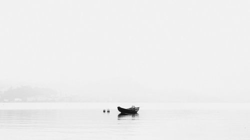 Scenic view of boat in sea against sky in foggy weather