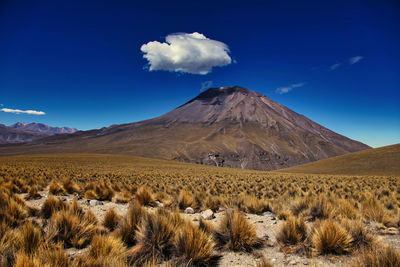 Scenic view of mountain range against blue sky