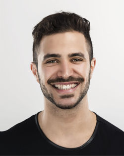 Portrait of smiling young man against white background