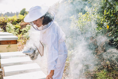 Young woman beekeeper at work in a nature