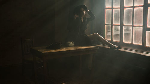 Woman sitting on table at home