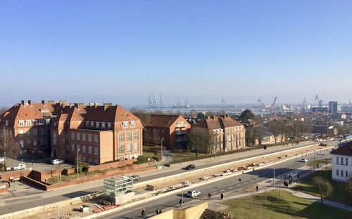 High angle view of city skyline with industrial harbor in the background