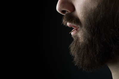 Portrait of man against black background