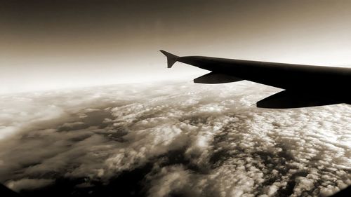 Airplane flying over cloudscape against sky