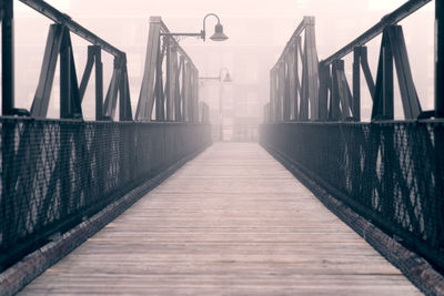 Empty footbridge against sky