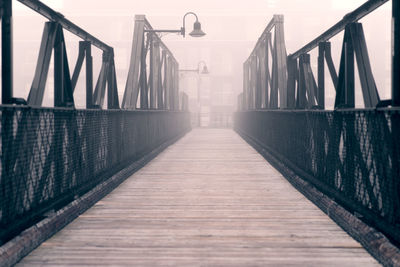 Empty footbridge during foggy weather