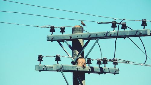 Low angle view of power line against clear blue sky