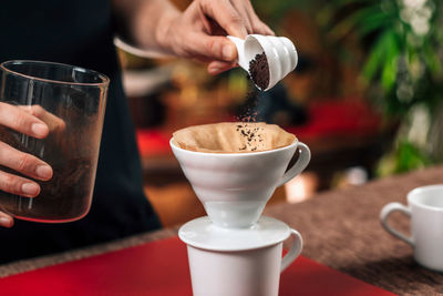 Midsection of woman making coffee in cafe