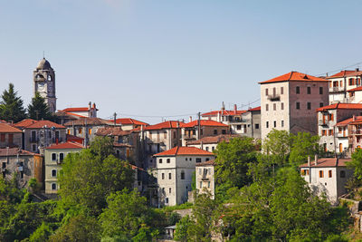 Buildings in town against clear sky