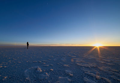 View of silhouette person on snow covered landscape