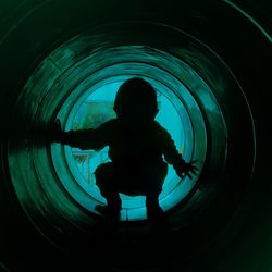 Rear view of silhouette boy in tunnel