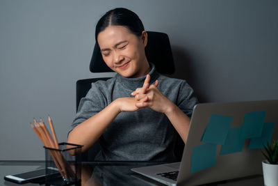 Young woman using mobile phone while sitting on table