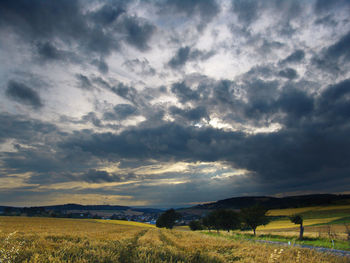 View of fields against cloudy sky