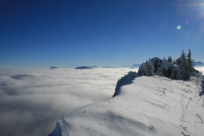 Scenic view of snow mountains against blue sky