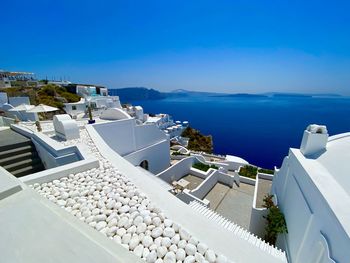 High angle view of sea by buildings against clear blue sky