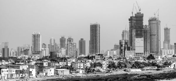 Buildings in city against clear sky