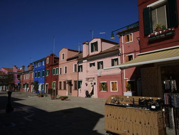 Buildings in city against clear blue sky