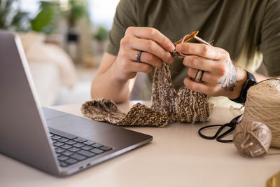 Midsection of woman using laptop on table