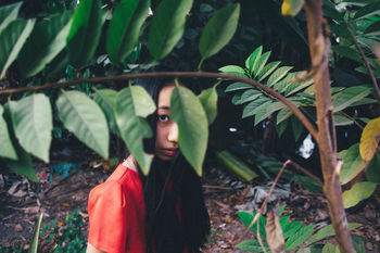 Portrait of girl standing by tree at field