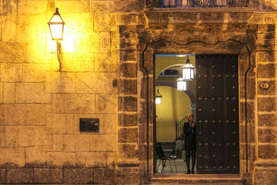 Illuminated street light against building