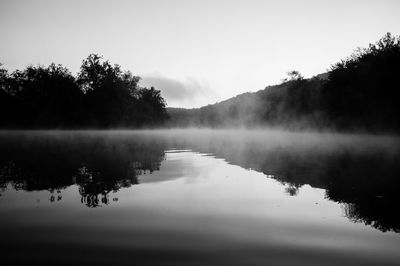 Scenic view of lake by trees against sky