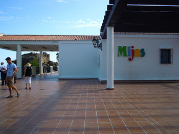 Rear view of people walking on building