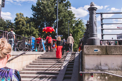 Rear view of people walking on steps by trees