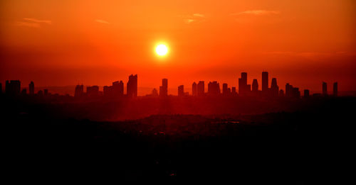 Silhouette buildings against sky during sunset