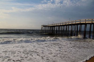 Pier over sea against sky during sunset