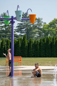 Rear view of woman sitting on slide in park