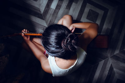 Rear view of woman sitting at home