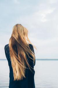 Rear view of woman looking at sea against sky