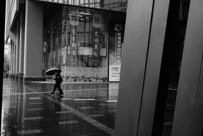 Man walking on street seen through glass window