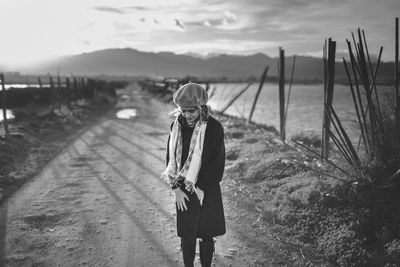 Teenage girl standing on dirt road