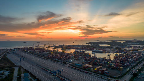 Aerial view of sunset sky at international cargo sea port.