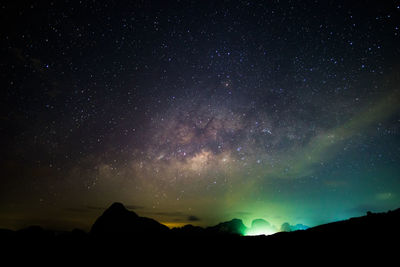 Low angle view of silhouette mountain against star field